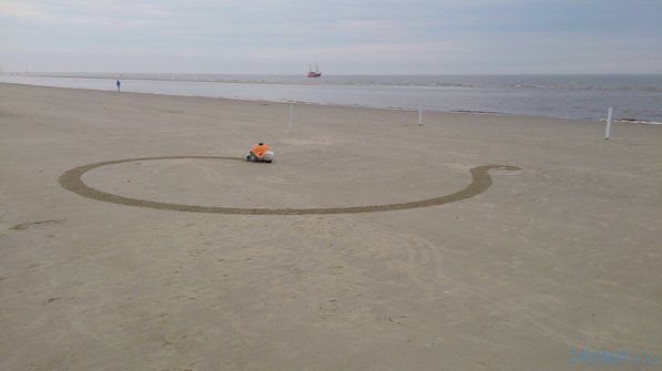 Робот рисует на песке