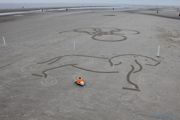 Робот рисует на песке